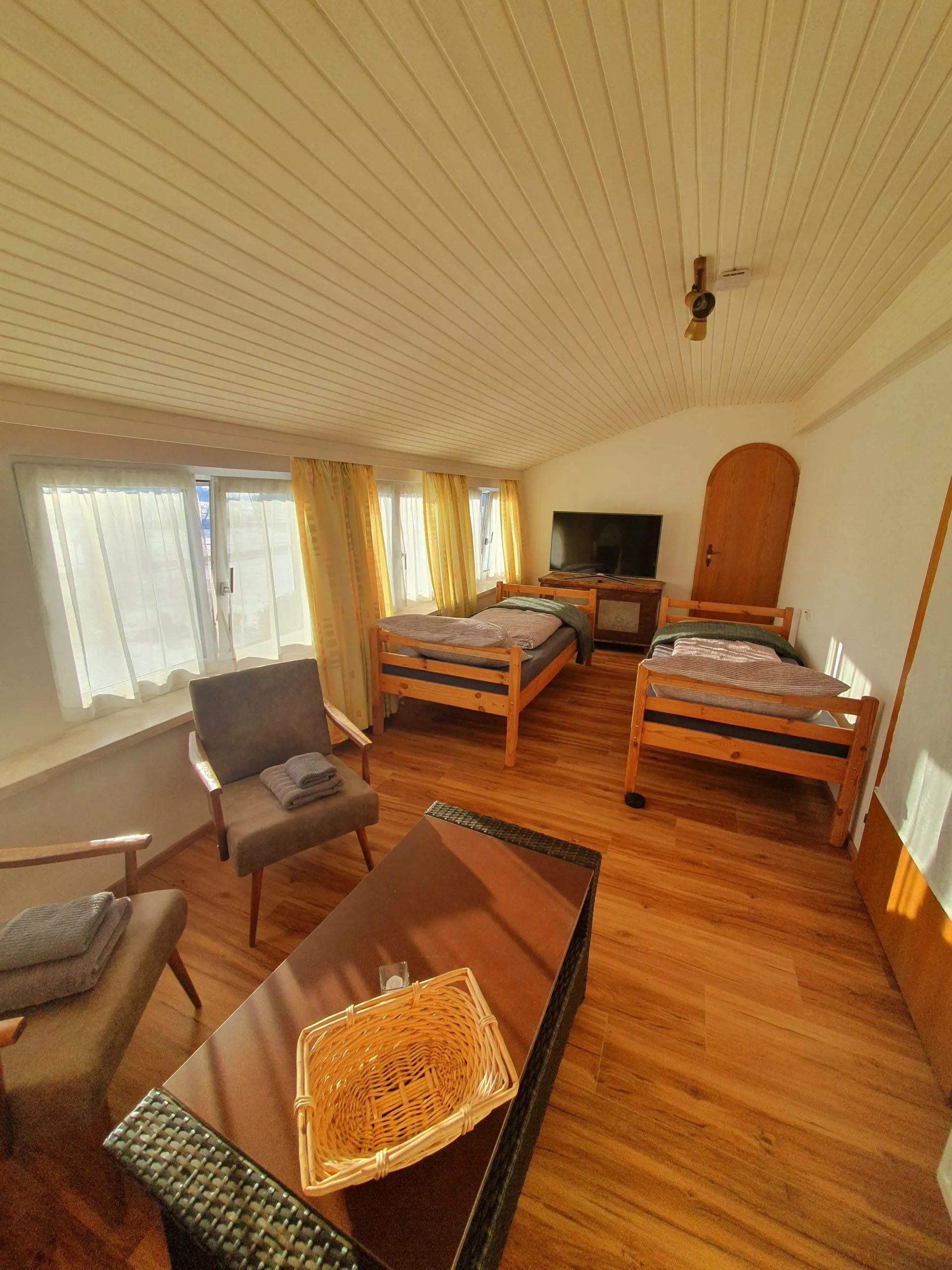 Schlafzimmer mit zwei Einzelbetten unter heller Holzdecke im Ferienhaus im Böhmerwald