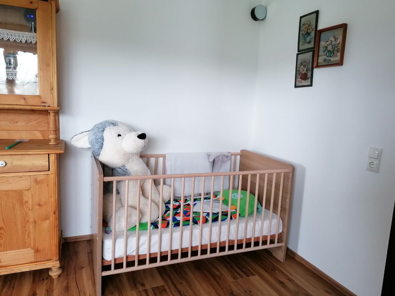 Gitterbett mit Kuscheltier in einem Schlafzimmer des Ferienhauses im Böhmerwald