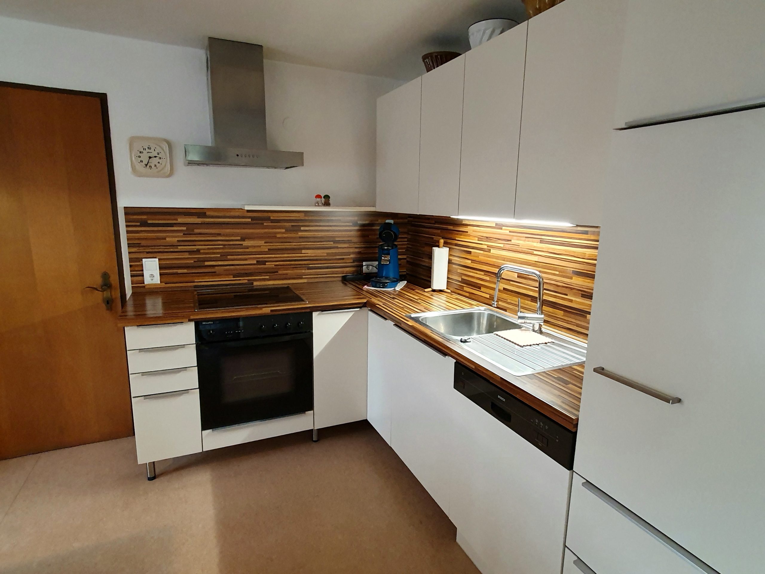 Küche mit Holz-Rückwand, Backofen und Geschirrspüler im Ferienhaus im Böhmerwald