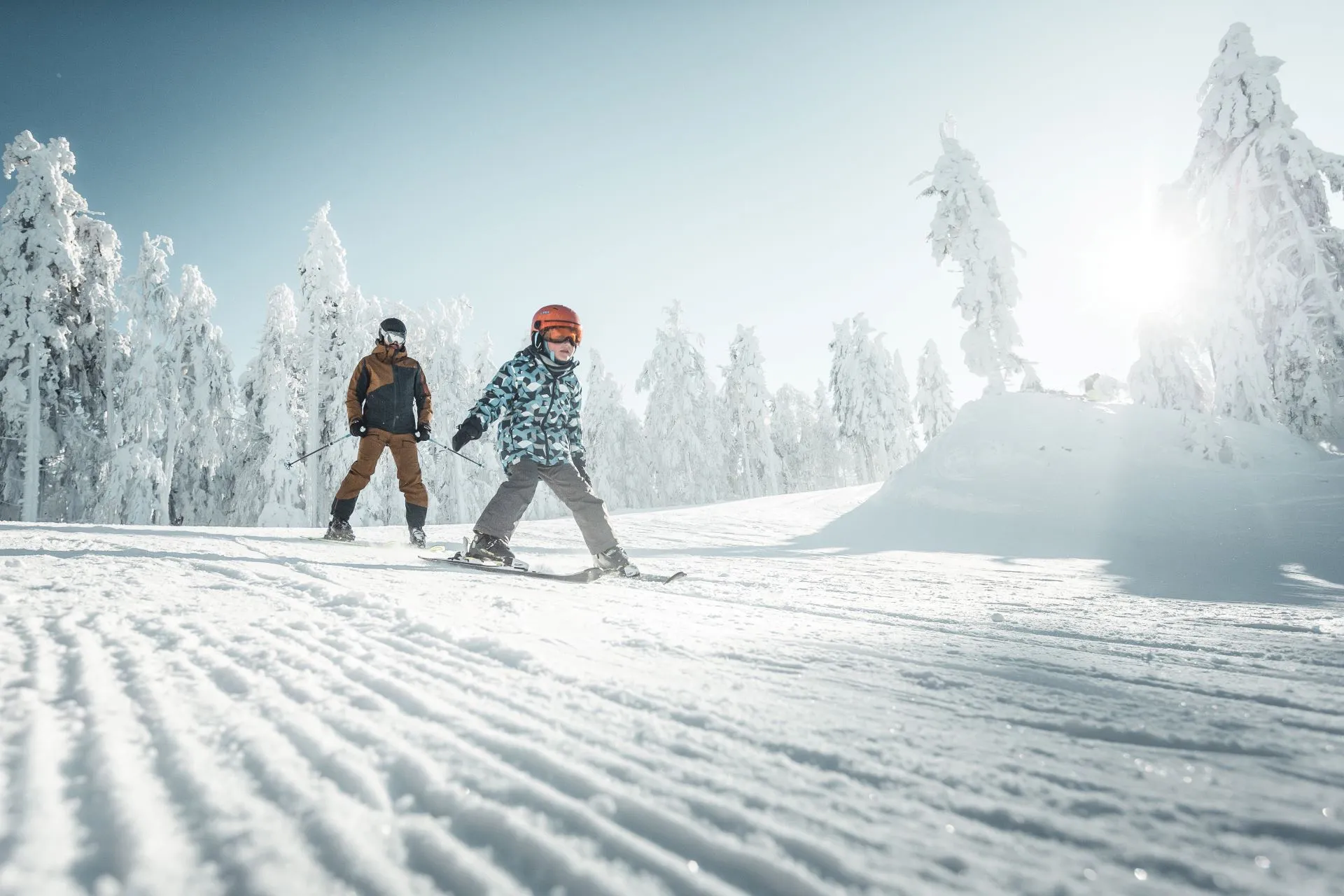 Kind und Erwachsener beim Skifahren auf der Piste am Hochficht in der Ferienregion Böhmerwald