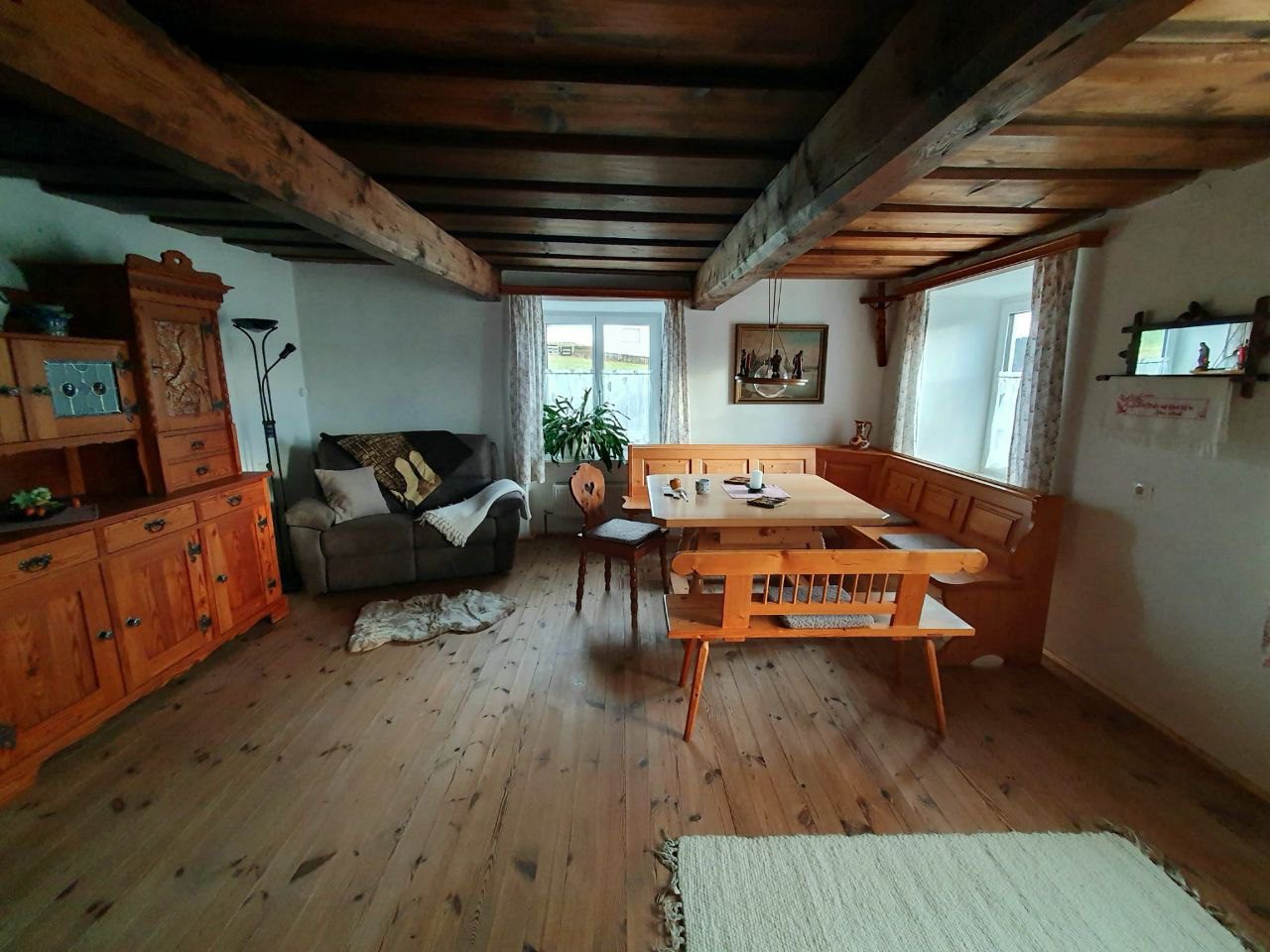 Stube mit Essbank, Sofa und Holzbalkendecke im Ferienhaus im Böhmerwald